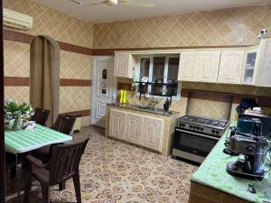 a kitchen with a table and a stove top oven at Rata in Seeb