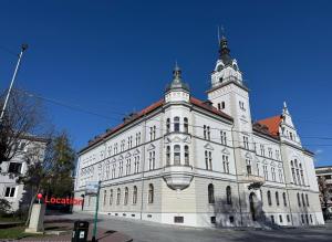 a large white building with a tower on top of it at Central Parc Apartment 1 ! Self Check-in ! Free Parking ! WiFi in Suceava