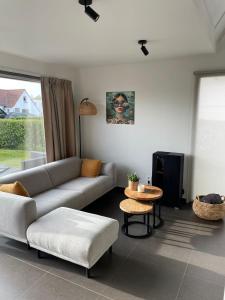 a living room with a couch and a table at Zanderover in Koksijde +17 photos