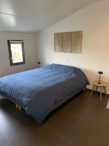 a bedroom with a bed with a blue comforter at Zanderover in Koksijde