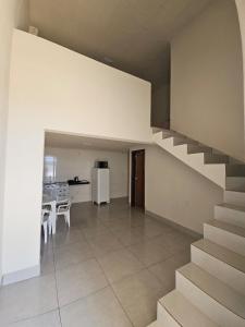 a living room with a staircase and a kitchen at Loft do Valle II in Sorriso