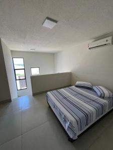 a bedroom with a bed in a white room at Loft do Valle II in Sorriso