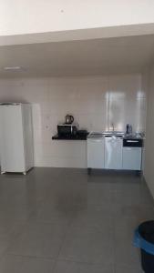 a kitchen with white appliances in a room at Loft do Valle II in Sorriso
