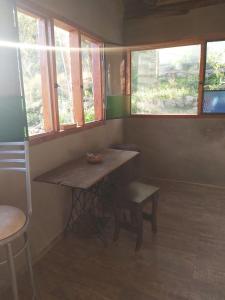 Habitación con mesa, silla y ventanas. en Pie de Sierra, en Los Hornillos
