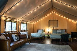a living room with a couch and a bed and lights at The Green Heron's Nest - Family Glamping Tent in Red River Gorge in Rogers