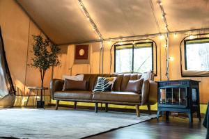 a living room with a couch and a fireplace at The Green Heron's Nest - Family Glamping Tent in Red River Gorge in Rogers