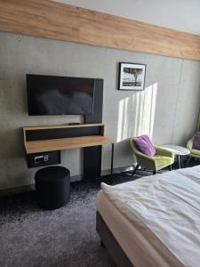 a bedroom with a bed and a flat screen tv at Czarna Perła Apartamenty Czarna Góra 512 in Sienna