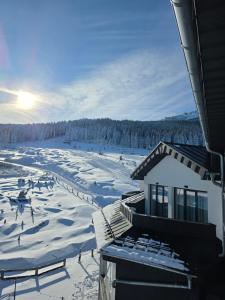 a ski lodge with snow on the ground and a ski slope at Czarna Perła Apartamenty Czarna Góra 512 in Sienna