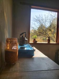 Una tetera colocada encima de una estufa junto a una ventana. en Pie de Sierra, en Los Hornillos 1 foto más