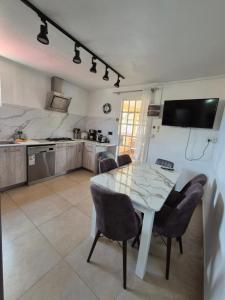 una cucina con un tavolo e sedie in una stanza di Jolie Villa Santa avec piscine a Pointe-aux-Piments