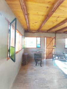 Habitación con techo de madera y mesa. en Pie de Sierra, en Los Hornillos