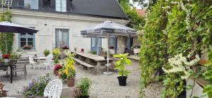 um pátio com uma mesa, cadeiras e um guarda-sol em Slitebadens Annex em Slite