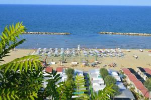 a beach with umbrellas and people on the beach at Camping Norina in Pesaro