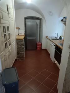 a kitchen with a refrigerator and a tile floor at Chalupa Domovina in Jiřetín pod Jedlovou +3 photos