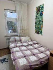 a bedroom with a bed with a plaid blanket at Large Appartment & Central Place in Tashkent +5 photos
