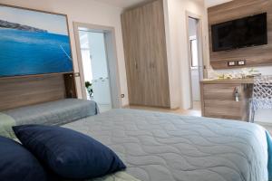 ein Schlafzimmer mit großem Bett und Flachbildfernseher in der Unterkunft Mary Vi Rooms in Peschici