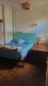 una camera con letto blu e pavimento in legno di Hostal Casa La Merced a Antigua Guatemala