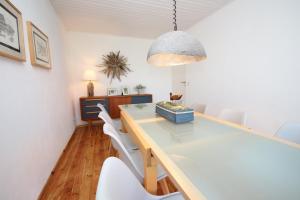 a dining room with a table and white chairs at Ferienhaus Düne in Rowy