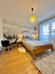 什切尔克Bar-Kawiarnia BASIA Pokoje Gościnne的卧室配有一张床和一张书桌,墙上挂有绘画作品