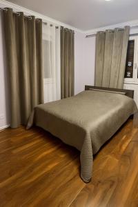 a bed in a bedroom with curtains and a wooden floor at Apartment Ebersheim France in Ebersheim