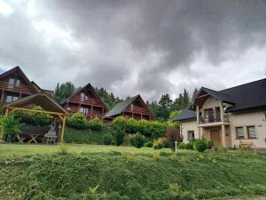un grupo de casas en una colina con nubes en el cielo en Słoneczny Brzeg Polańczyk-Dom na wyłączność, en Myczków