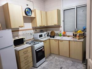 a kitchen with a stove and a microwave at Eden Cozy Airport in El Aouina Station +7 photos