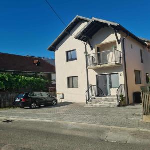 a car parked in front of a white house at Casa Marm in Călimăneşti