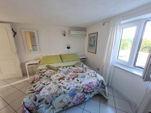 a bedroom with a bed with a floral comforter at Home sweet home in Ischia