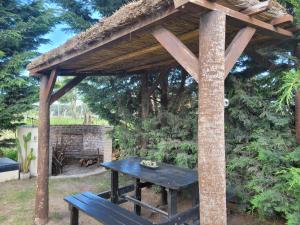 un tavolo da picnic sotto un padiglione con panchina di Finca131 a Necochea