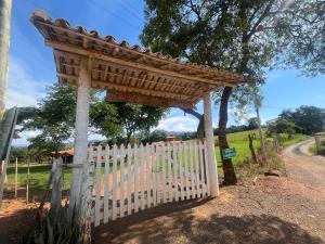 a wooden gate with a white fence at Chalés Terra Santa Capitólio in Capitólio