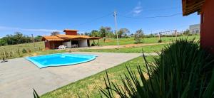 a swimming pool in a yard with a house at Chalés Terra Santa Capitólio in Capitólio