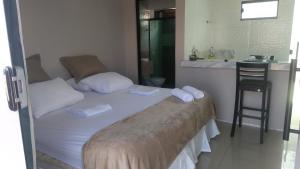 a small bedroom with a bed and a chair at Barcel Flat in Teresina