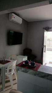 a living room with a kitchen and a table with chairs at Barcel Flat in Teresina