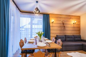 een eetkamer met een tafel en een bank bij Burnosówka in Nowy Targ