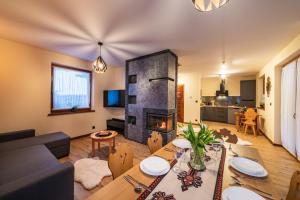 een woonkamer met een tafel en een open haard bij Burnosówka in Nowy Targ