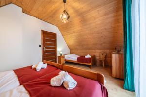 een slaapkamer met twee bedden met handdoeken erop bij Burnosówka in Nowy Targ