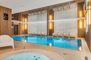 a pool in a room with a tub at Baltic Dream - SPA - Basen - Parking - Kids Room in Ustronie Morskie