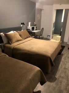 朗布依埃Hôtel Saint - Charles的配有桌子和桌子的客房内的两张床