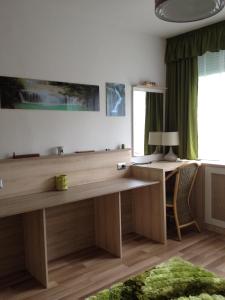 a large wooden desk in a room with a window at Mikes Apartman in Szekszárd