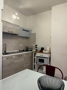 a kitchen with a table and a stove top oven at Urban House in Nuoro +5 photos