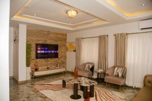 拉各斯4 bedroom semi detached townhouse in Old Ikoyi的一间客厅,在砖墙上配有电视