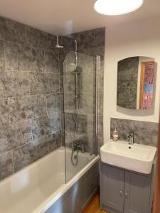 a bathroom with a tub and a sink and a shower at Eastfields Farm Barns in Melchbourne +32 photos