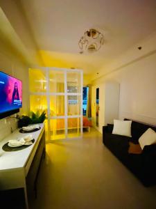 a living room with a couch and a tv at ASV Condo Staycation SMDC Breeze in Manila