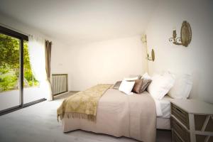 a white bedroom with a bed and a window at Villa Ruzanna in Mandelieu-La Napoule