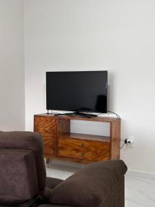 una TV a schermo piatto seduta sopra un centro di intrattenimento in legno di Apartamento noCentro de Guarapuava a Guarapuava
