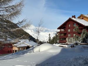 un cumulo di neve di fronte a un edificio di Appartement de Standing - ARC 1950 - 6 personnes - départ et retour à skis ad Arc 1950