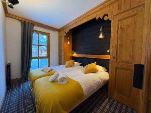 una camera da letto con due letti con asciugamani sopra di Appartement de Standing - ARC 1950 - 6 personnes - départ et retour à skis ad Arc 1950