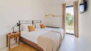 two beds in a white room with a window at Quinta da Lameirinha Douro, Boutique Home in Baião +24 photos