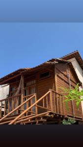 een houten huis met een houten trap en een balkon bij Chalé do beco,flecheiras in Trairi