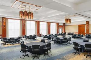 una grande stanza con tavoli, sedie e finestre di Eaglewood Resort & Spa a Itasca Altre 99 foto